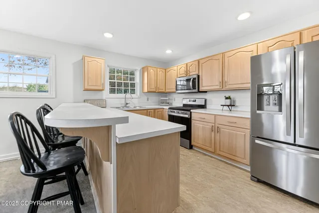 a kitchen with a refrigerator a stove a sink and white cabinets with wooden floor