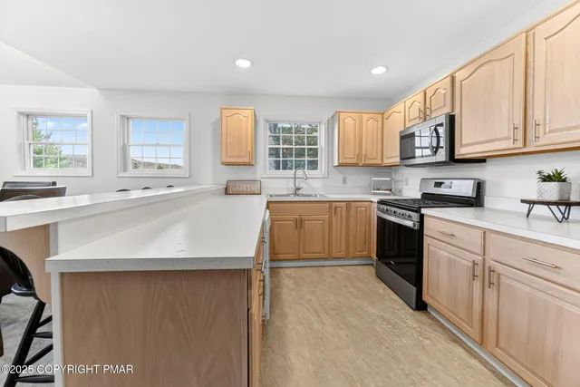 a kitchen with stainless steel appliances granite countertop a sink counter space cabinets and a large window