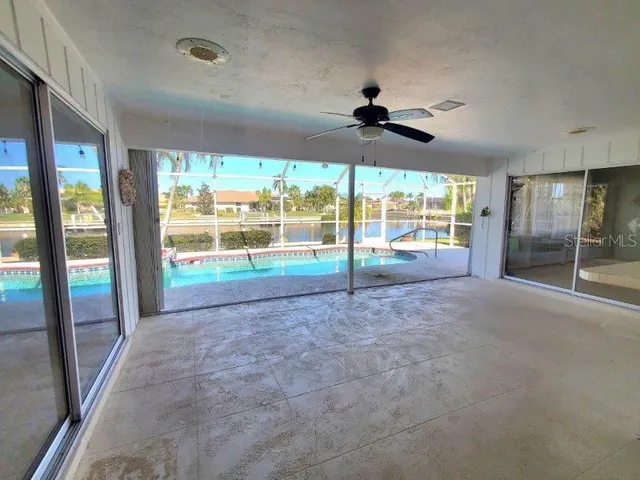 a view of an empty room with windows and a ceiling fan