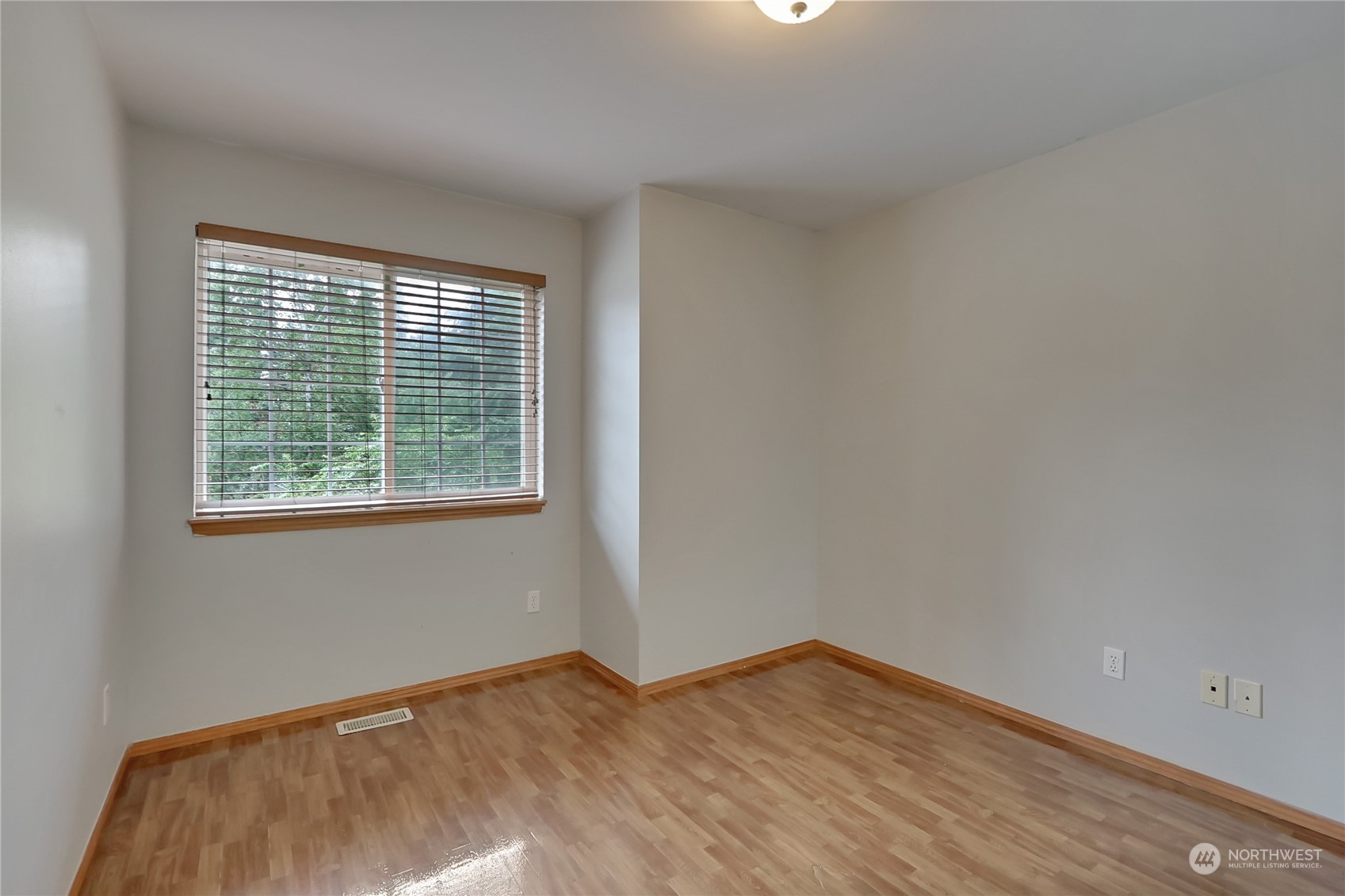 3430 201st Place Southeast Bothell, WA 98012 - Photo 23 of 32 a view of an empty room with wooden floor and a window
