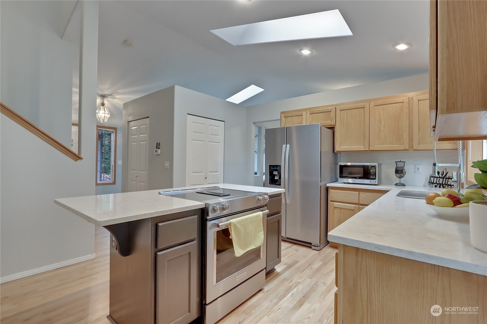 3430 201st Place Southeast Bothell, WA 98012 - Photo 10 of 32 a kitchen with a stove a sink a refrigerator and white cabinets with wooden floor