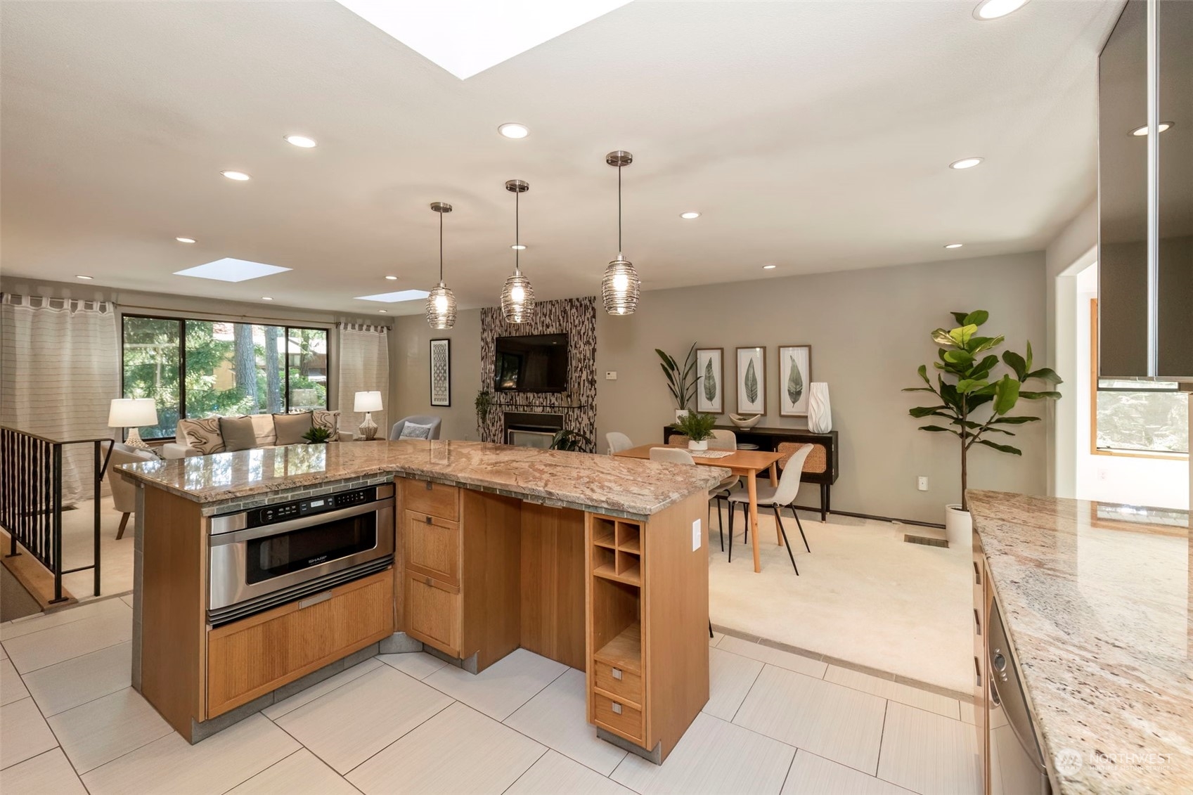 5695 Southwest 44th Street Port Orchard, WA 98367 - Photo 12 of 40 a kitchen with stainless steel appliances kitchen island granite countertop a table and chairs in it