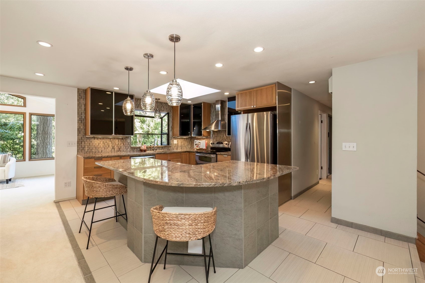 5695 Southwest 44th Street Port Orchard, WA 98367 - Photo 10 of 40 a kitchen with stainless steel appliances kitchen island granite countertop a sink and a refrigerator