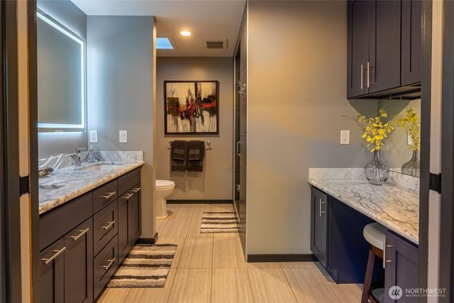 a spacious bathroom with a granite countertop sink and a mirror