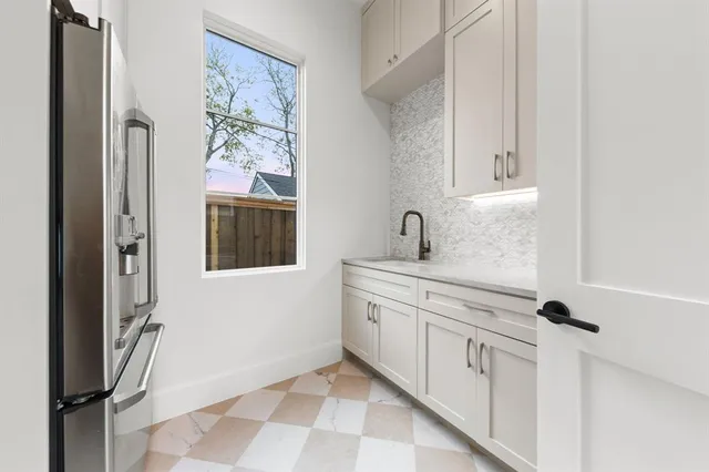 a hallway with white cabinets and window