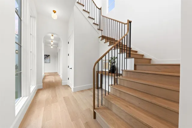 a view of a hallway with wooden floor and cabinet
