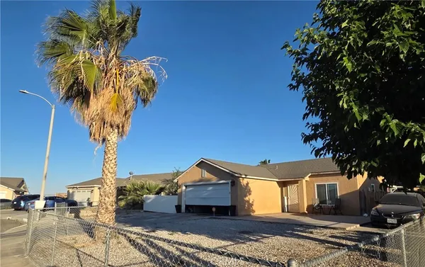 a view of a house with a large tree and a yard