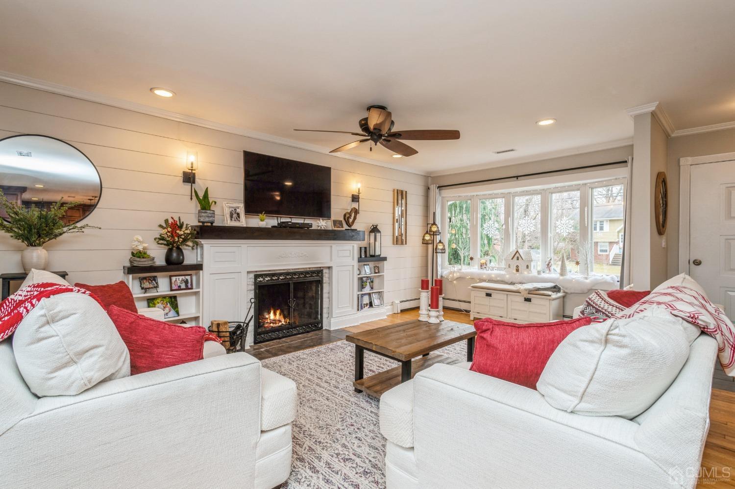 87 Stony Road Edison, NJ 08817 - Photo 3 of 26 a living room with furniture a flat screen tv and a fireplace