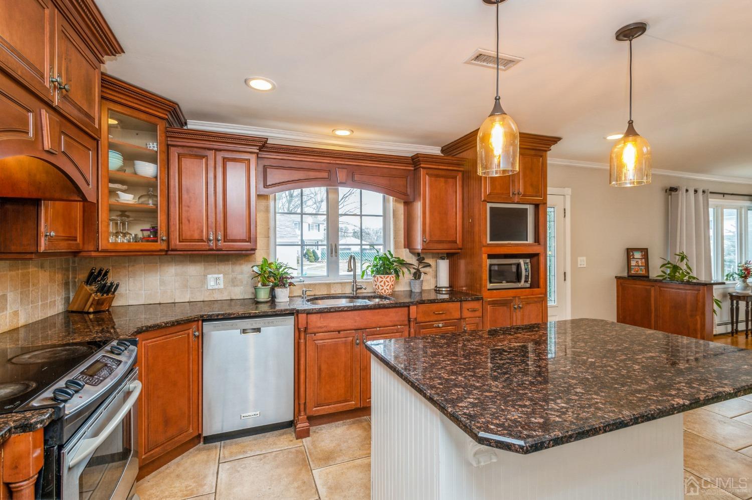 87 Stony Road Edison, NJ 08817 - Photo 9 of 26 a kitchen with stainless steel appliances granite countertop a sink a stove and a wooden floors