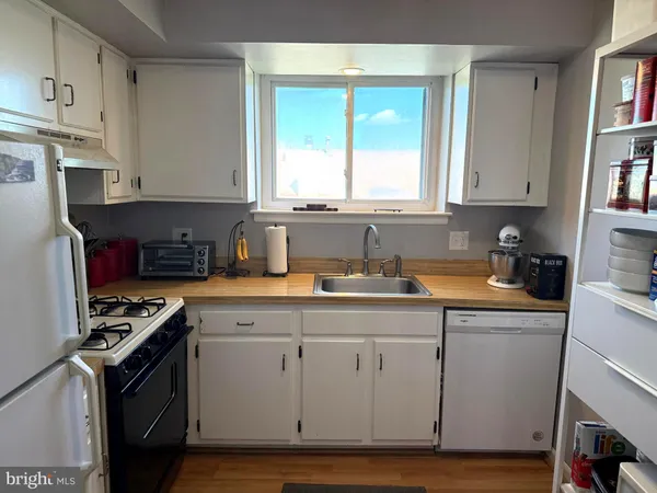 a kitchen with cabinets appliances a sink and a window