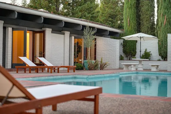 a view of a house with backyard and sitting area