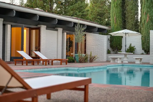 a view of a house with backyard and sitting area