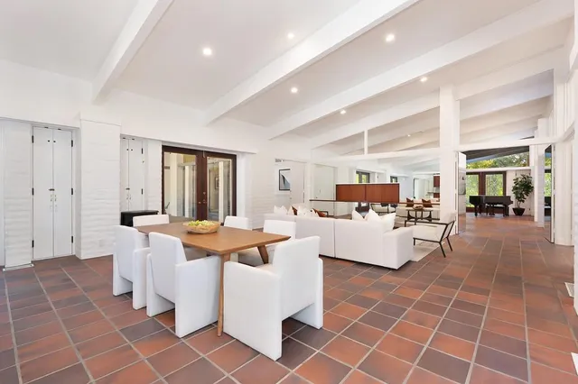 a spacious bedroom with a bed a window and dresser