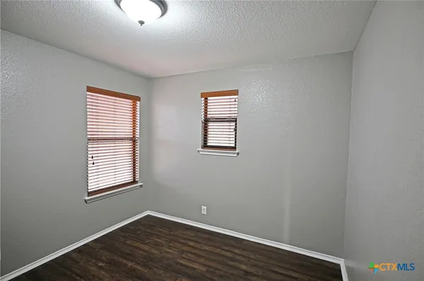 an empty room with wooden floor and closet
