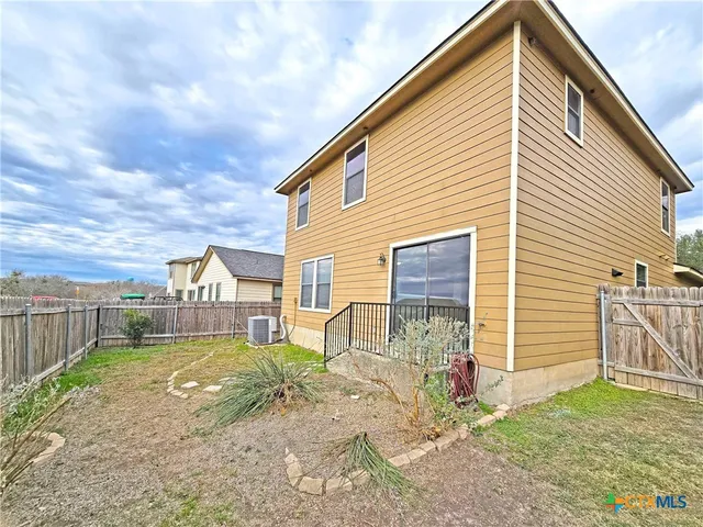 a view of a backyard with wooden fence