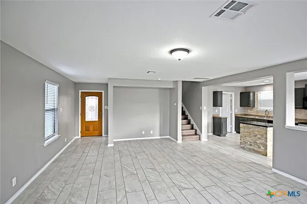 a view of a livingroom with wooden floor and stairs