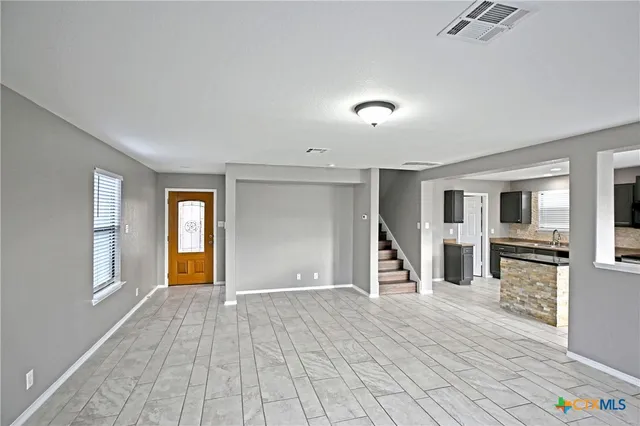 a view of a livingroom with wooden floor and stairs