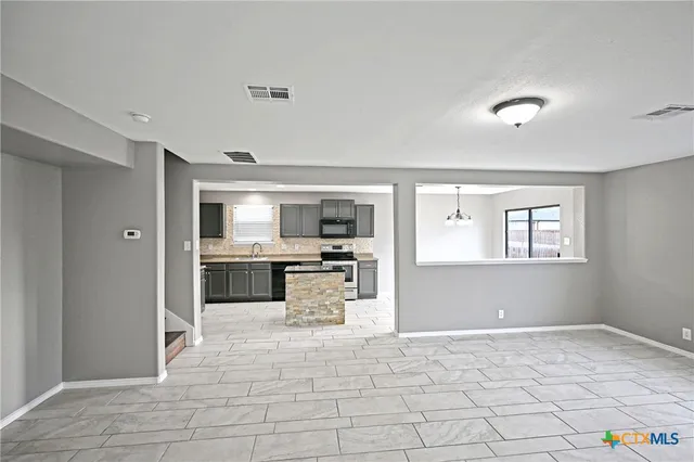 a large white kitchen with a stove and a refrigerator