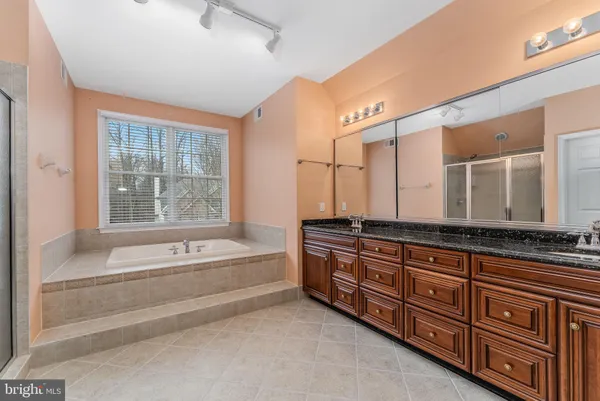 a spacious bathroom with a granite countertop tub sink and mirror