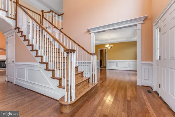 a view of staircase with railing and a chandelier