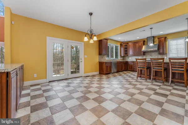 a view of a kitchen with kitchen island stainless steel appliances a stove a sink a counter top space and cabinets