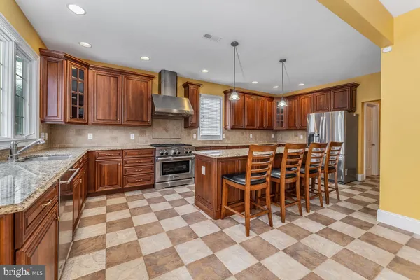 a kitchen with stainless steel appliances granite countertop a stove a sink and a refrigerator