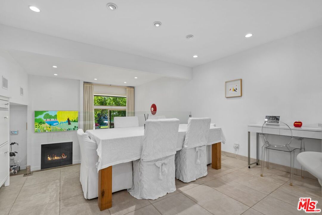 13231 Fiji Way, Unit F Marina del Rey, CA 90292 - Photo 15 of 40 a living room with fireplace furniture a dining table and a garden