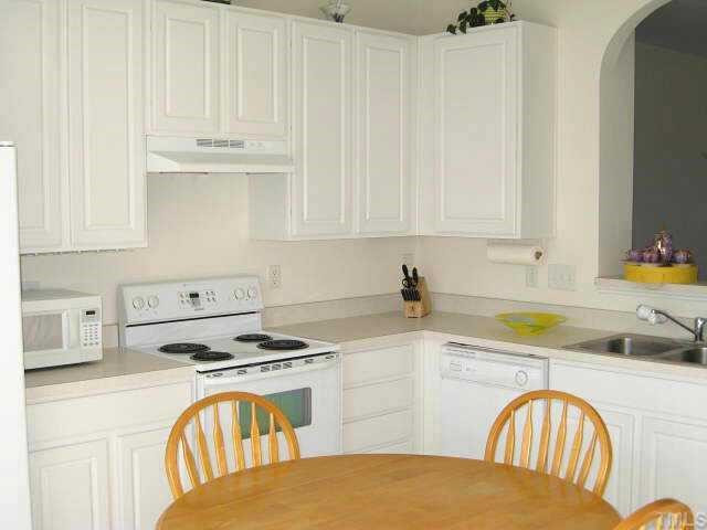 Spacious kitchen with breakfast area & white cabinets/appliances Other