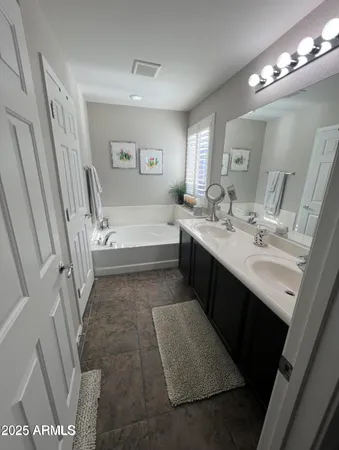 a bathroom with a tub sink vanity granite and toilet