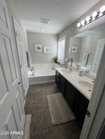 a bathroom with a tub sink vanity granite and toilet