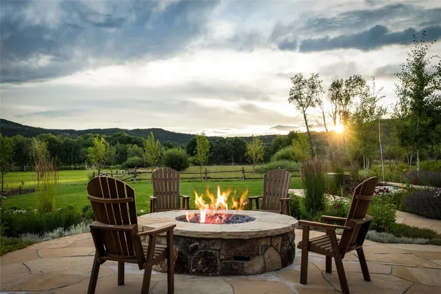 a backyard of a house with table and chairs