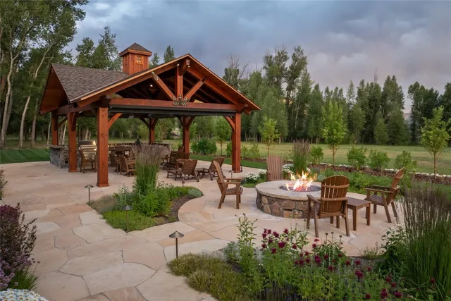 a view of a patio with couches chairs and a table and chairs under an umbrella