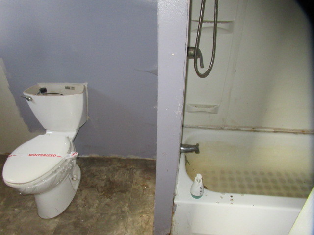 19608 Henning Road Danville, IL 61834 - Photo 9 of 9 a white toilet sitting next to a bath tub and shower