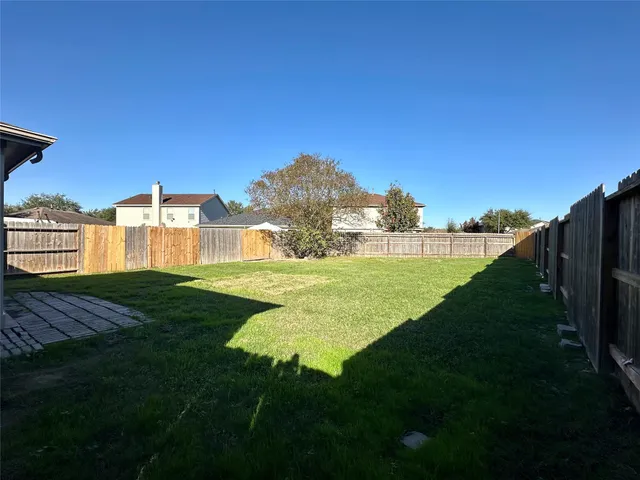 a view of a house with backyard and a tree