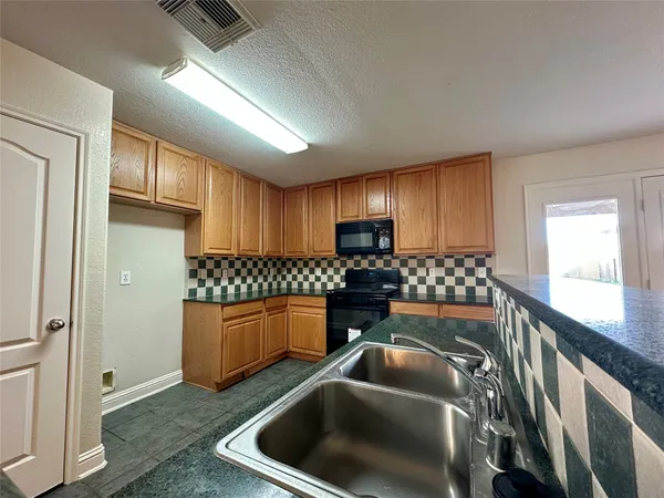 a kitchen with stainless steel appliances granite countertop a refrigerator a sink and wooden cabinets