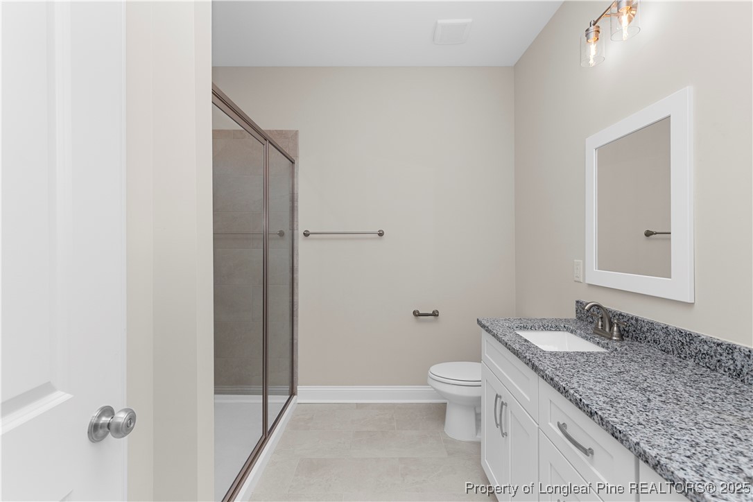 162 Surles Landing Way Benson, NC 27504 - Photo 17 of 28 a bathroom with a granite countertop sink toilet and shower