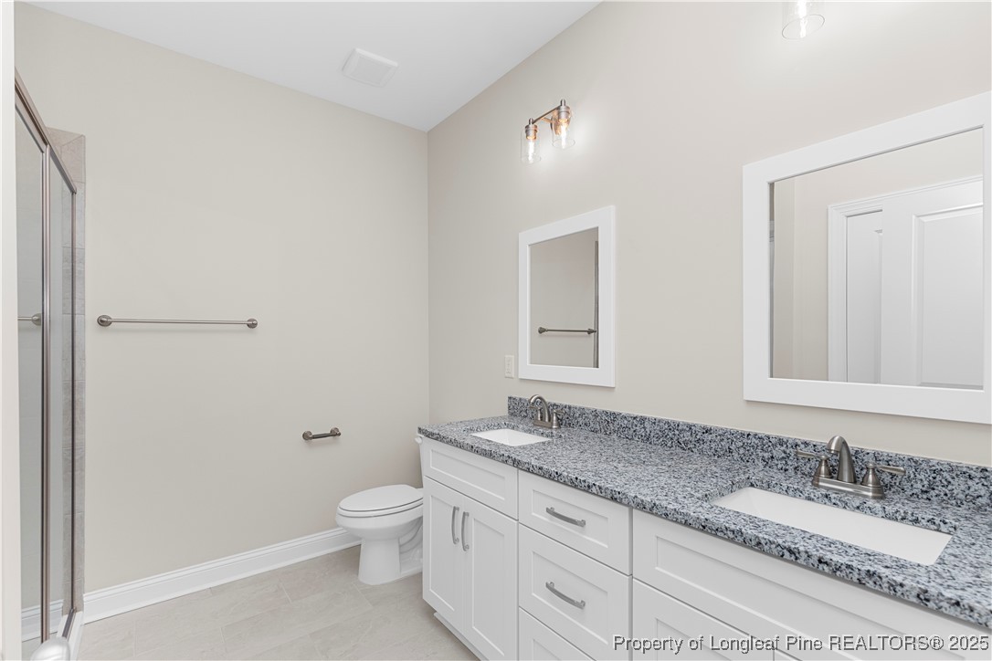 162 Surles Landing Way Benson, NC 27504 - Photo 18 of 28 a bathroom with a granite countertop sink a toilet and shower