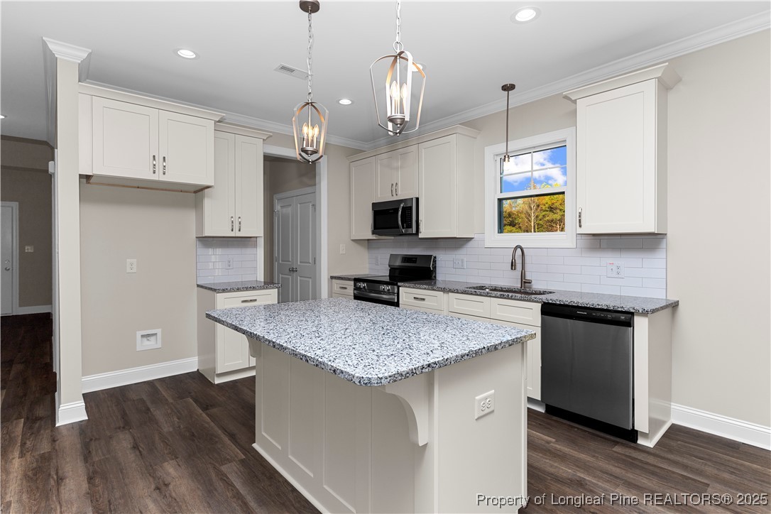 162 Surles Landing Way Benson, NC 27504 - Photo 8 of 28 a kitchen with a center island wooden floor and stainless steel appliances
