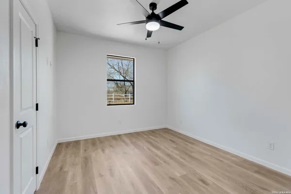an empty room with a window and a ceiling fan