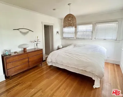 a spacious bedroom with a bed and a dresser