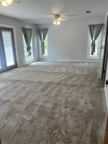 an empty room with windows and closet