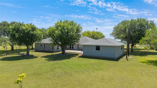 a view of a house with a yard garage and tree