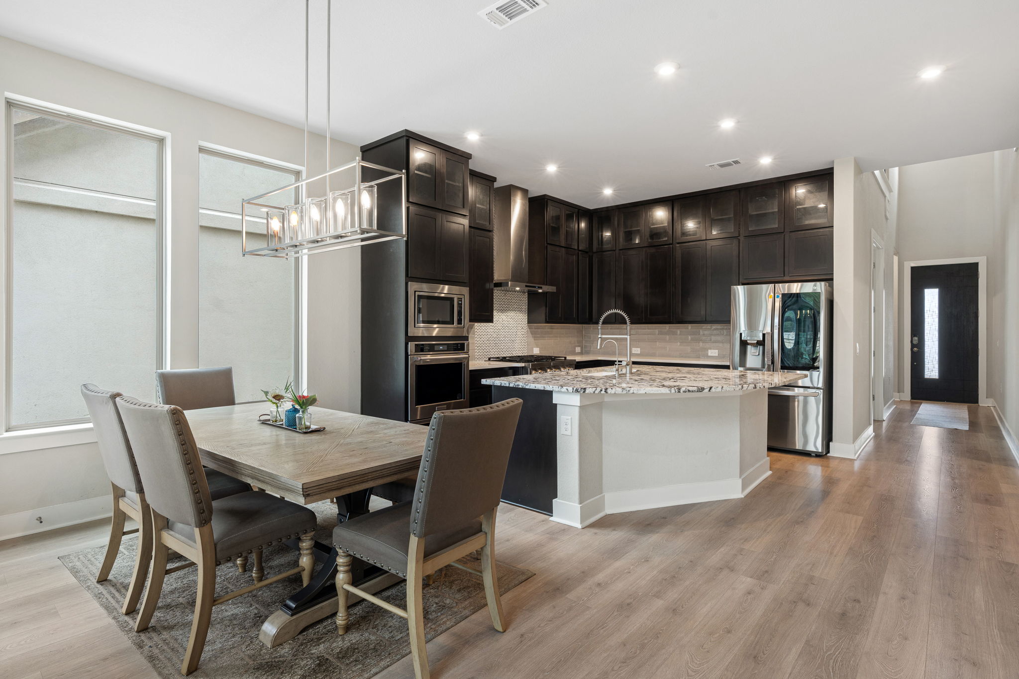 244 Diamondback Drive Georgetown, TX 78628 - Photo 12 of 37 Open-concept kitchen and dining area featuring dark cabinetry, stainless steel appliances, a large island with a sink.