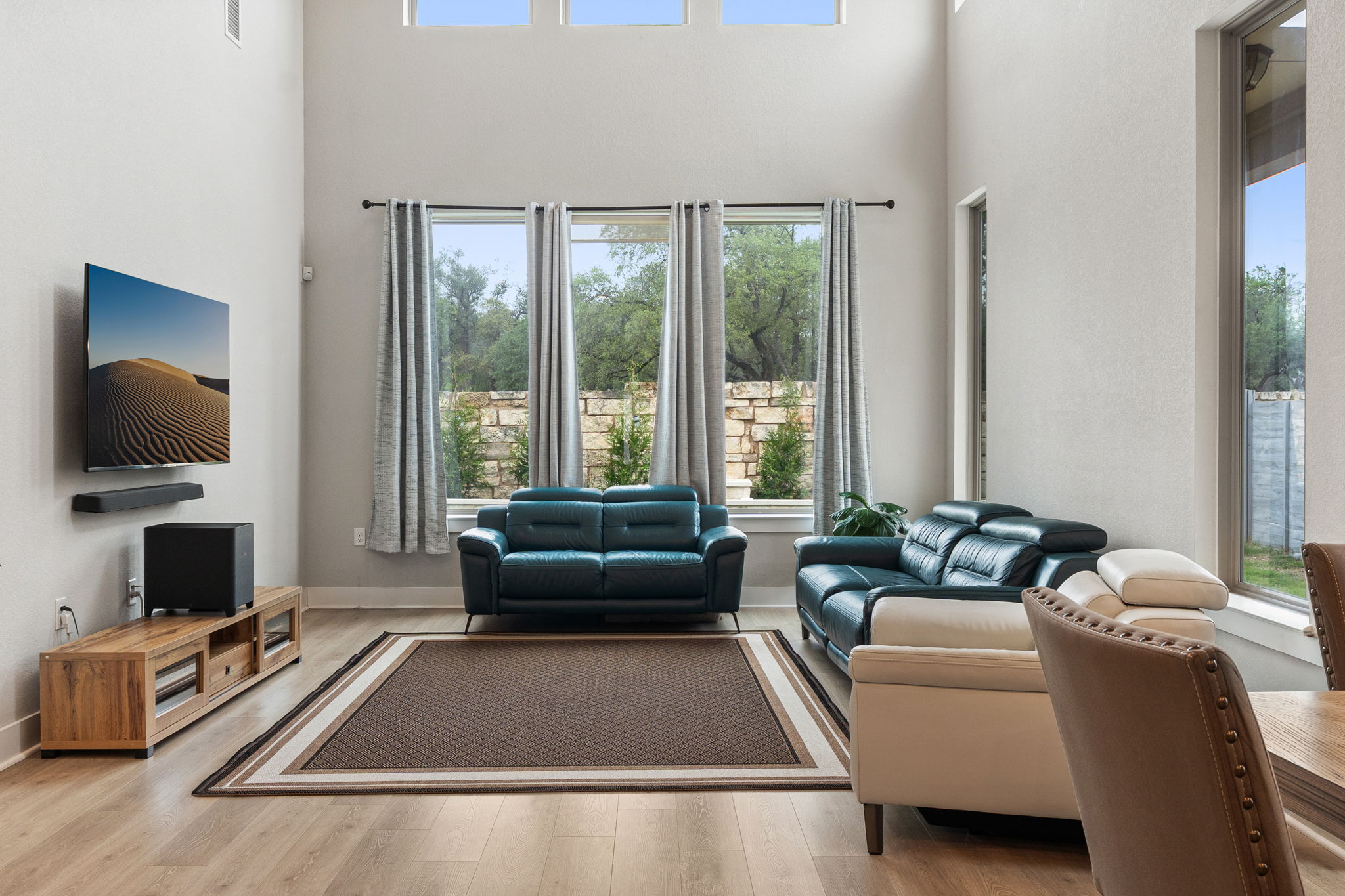 244 Diamondback Drive Georgetown, TX 78628 - Photo 14 of 37 Double-height living space featuring a wall of three tall windows, and upper transom windows.