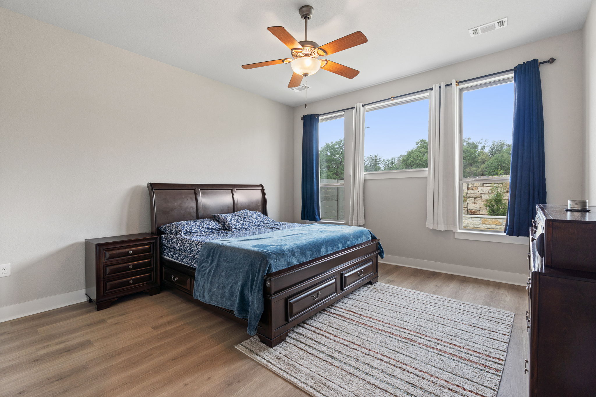 244 Diamondback Drive Georgetown, TX 78628 - Photo 18 of 37 Spacious bedroom with a ceiling fan with integrated lighting, and three large windows.