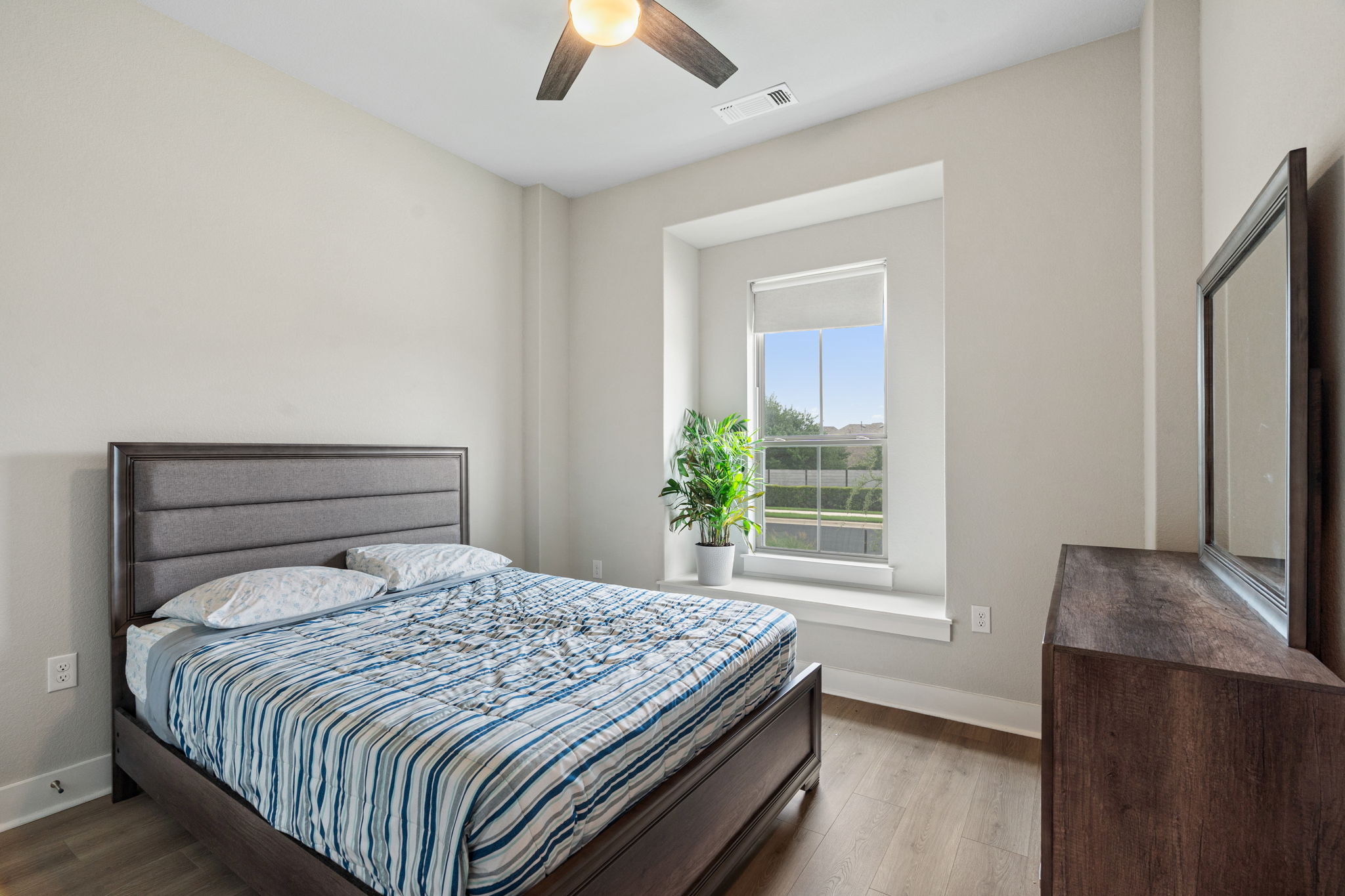 244 Diamondback Drive Georgetown, TX 78628 - Photo 23 of 37 Bedroom featuring wood-finish flooring, a window with roller shade, and a ceiling fan with integrated lighting