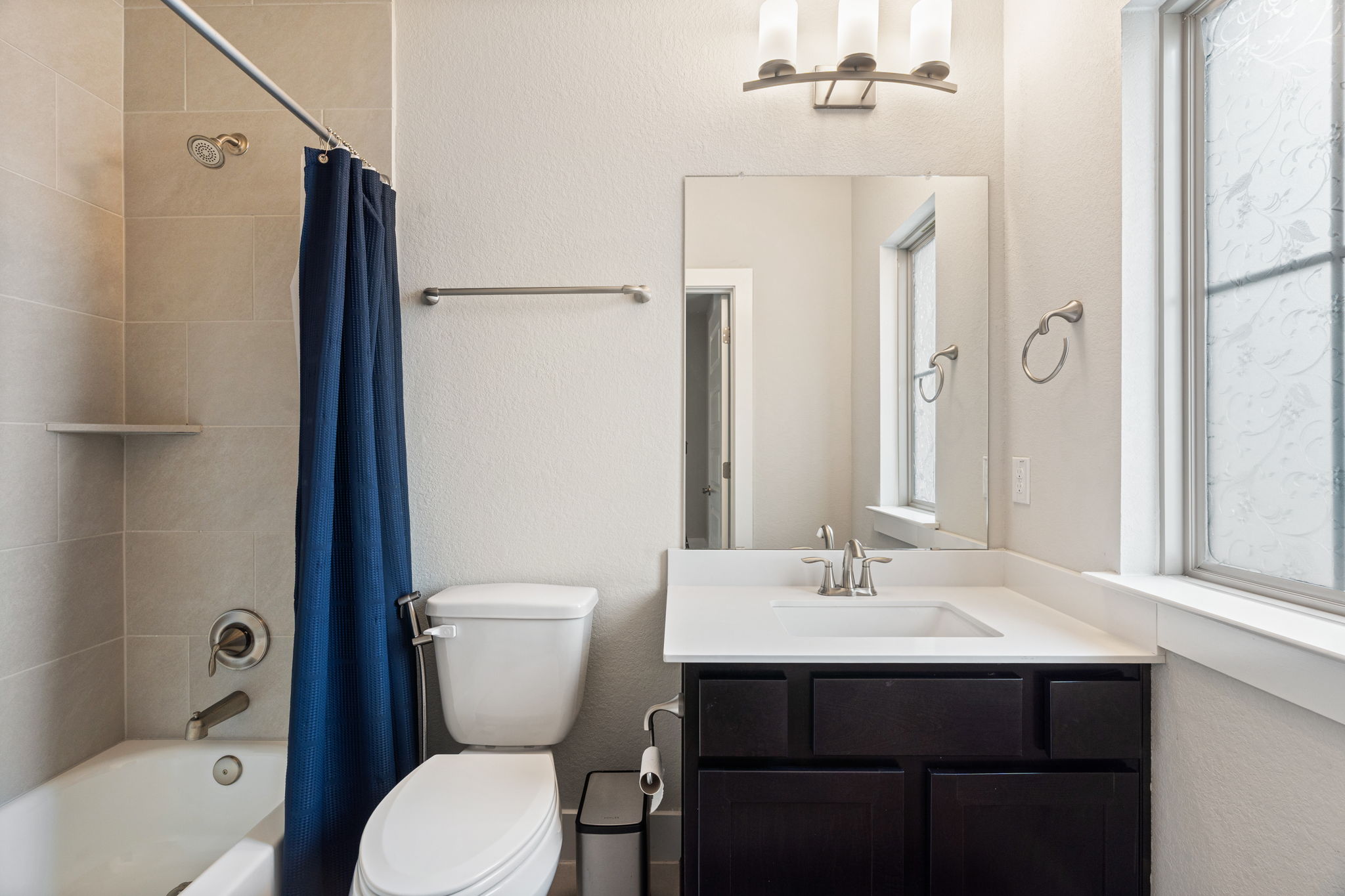 244 Diamondback Drive Georgetown, TX 78628 - Photo 29 of 37 Bathroom featuring a dark wood-finish vanity with a white countertop and integrated sink, a rectangular mirror, and a three-light vanity fixture.