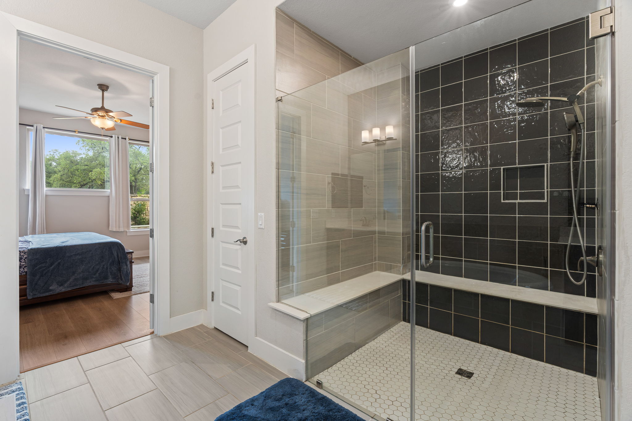 244 Diamondback Drive Georgetown, TX 78628 - Photo 6 of 37 Spacious bathroom featuring a glass-enclosed shower with dark tile surround, and a built-in bench.