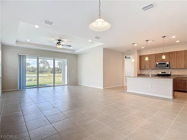 a view of an empty room and kitchen with a floor to ceiling window