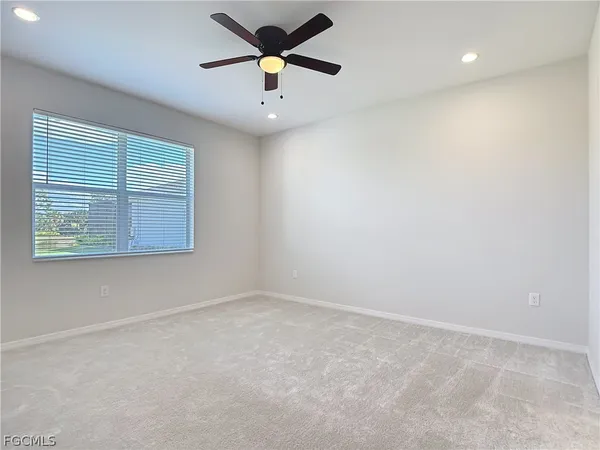 an empty room with a window and a fan